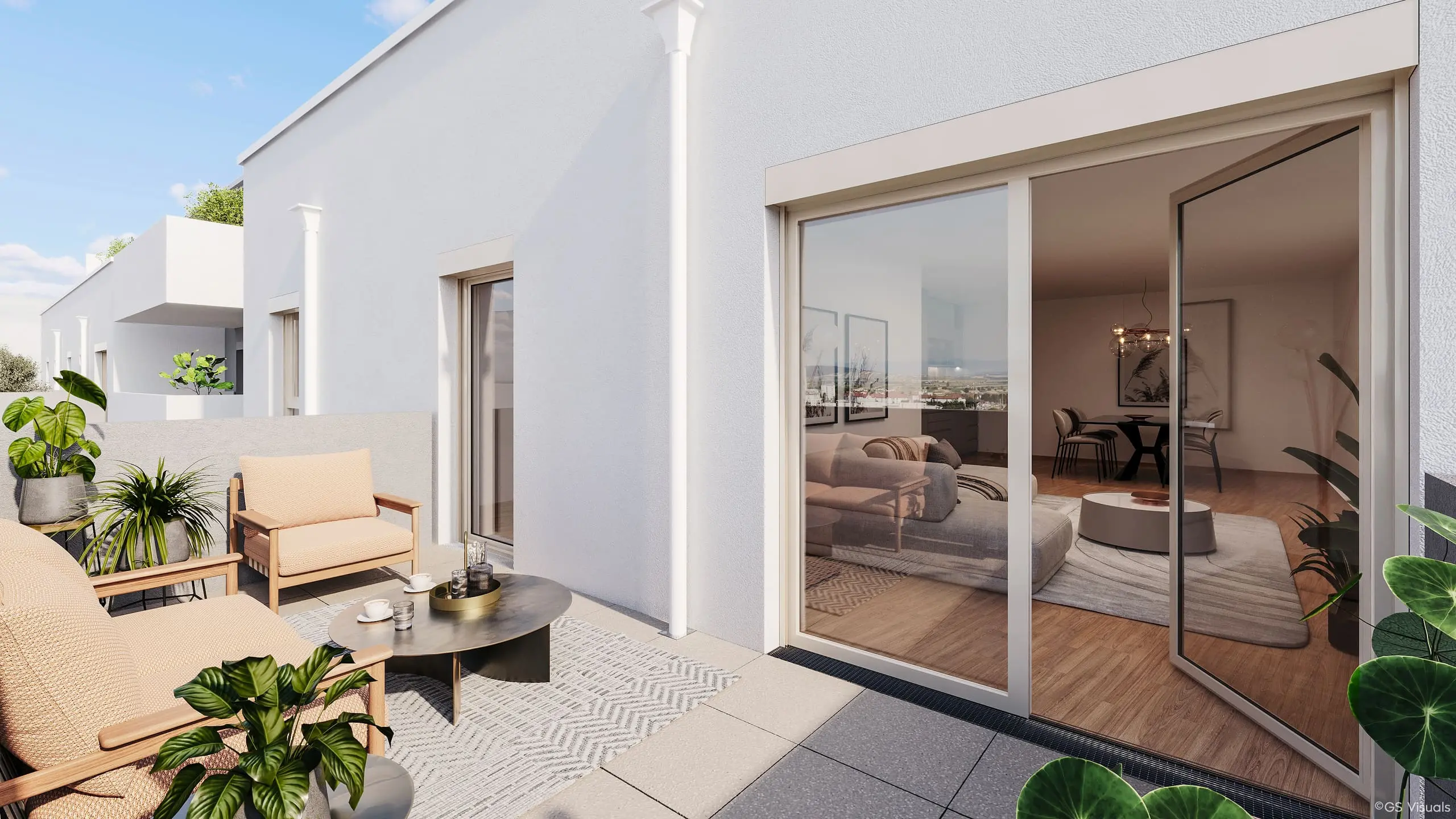 Terrasse mit Loungesesseln und Pflanzen, dahinter der Wohnraum hinter einer Schiebetür